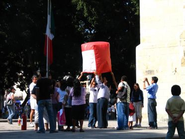 Sur la place, les jeunes font voler de petites montgolfieres