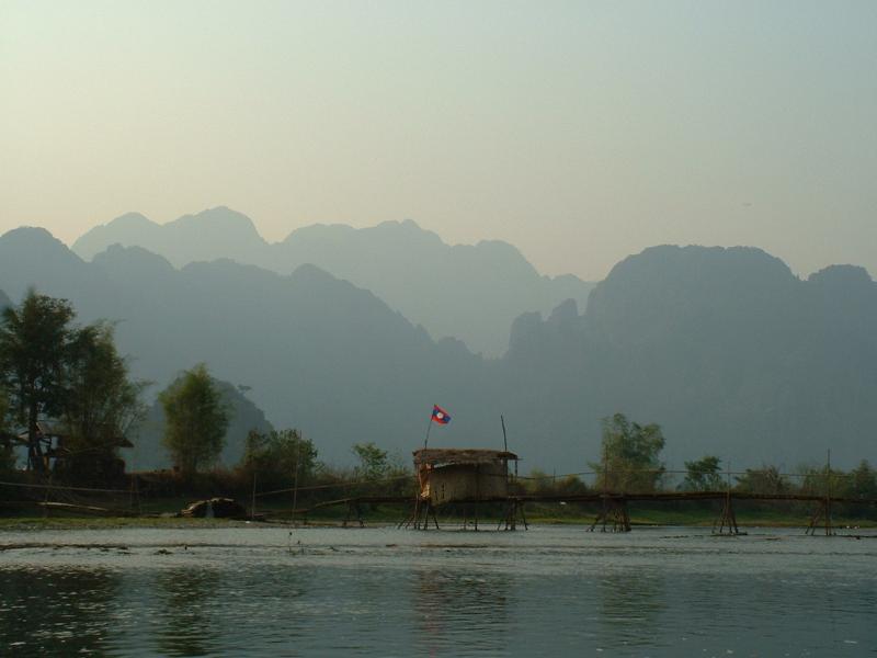 Le drapeau du Laos flotte fièrement sur une cabane de pêcheur